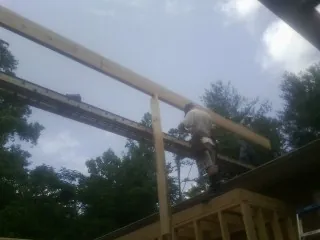 Carpenter setting a ridge beam over a new addition frame — Ice Dam Removal by Roofing Brothers in Carver