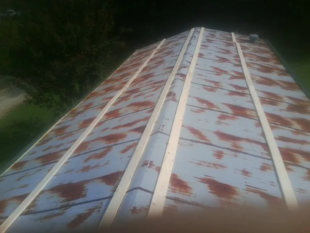 Rusted metal roof panels with new wood purlins before replacement — Storm Damage Roof Repair in Carver by Roofing Brothers